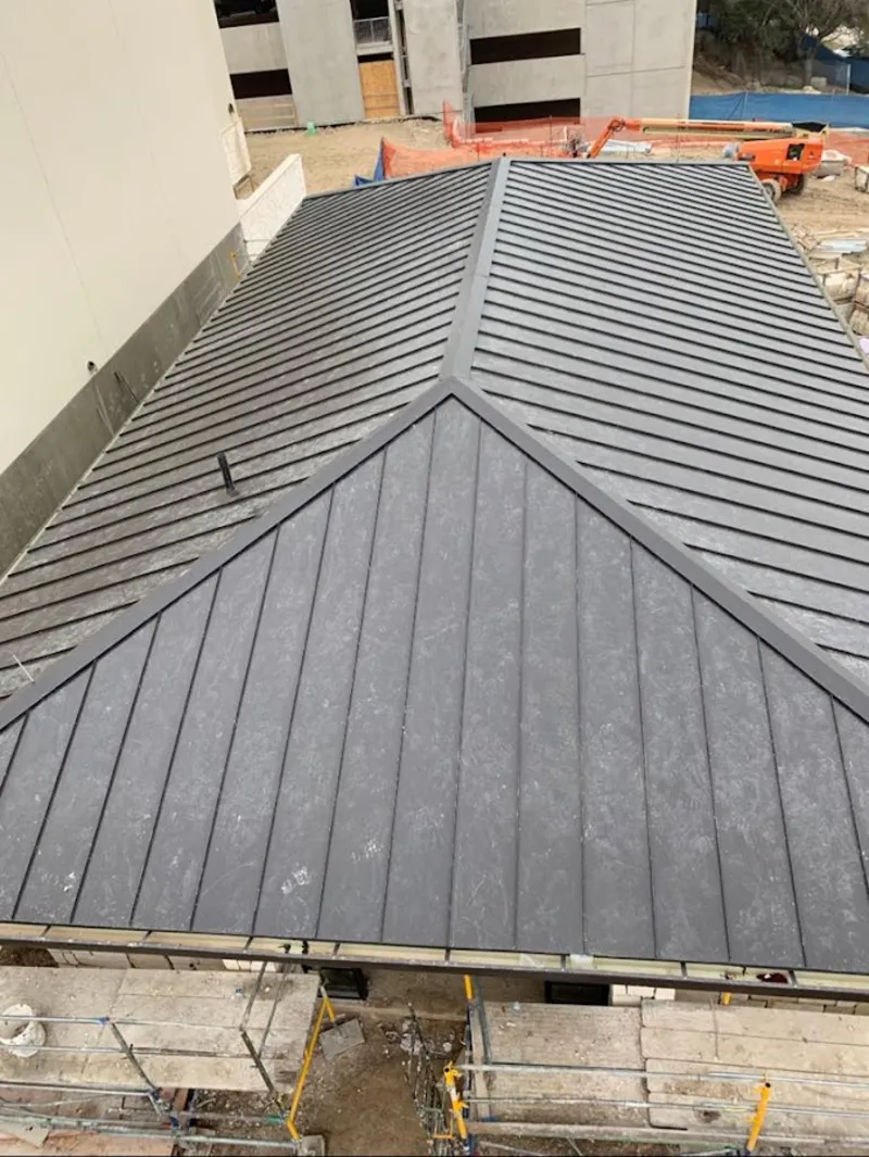 Commercial metal roof construction with crane equipment in Norwalk